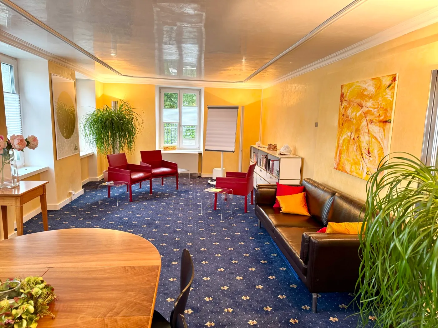 Blick in den Therapieraum mit Sitzecke, Sofa und Pflanzen, freundlich und einladend gestaltet